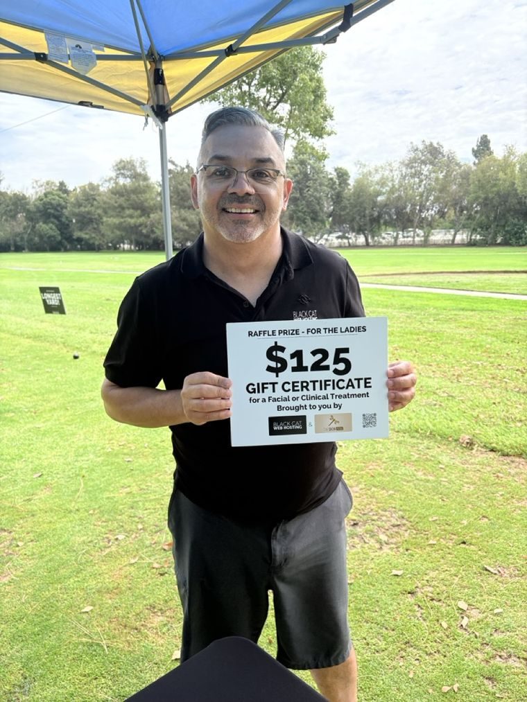 Carlos holding the raffle prize sign for the tournament.