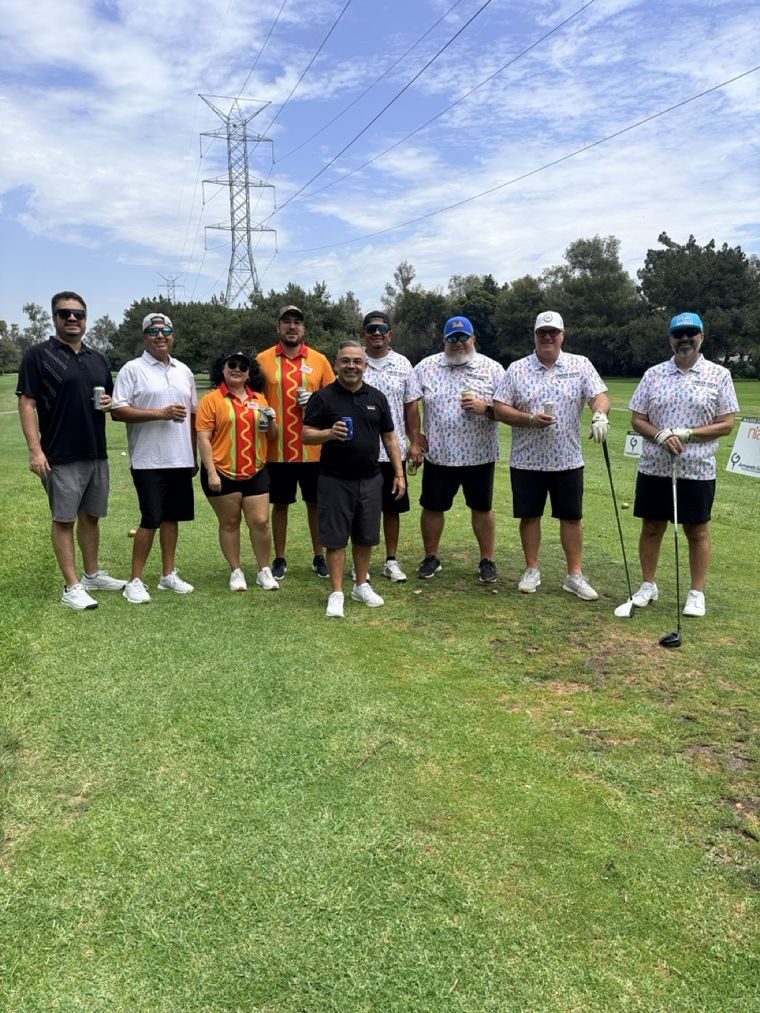 A foursome and friends gathered at the tee.